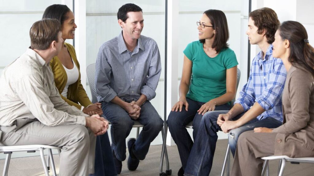 People sharing experiences with each other during a group therapy session at polysubstance abuse treatment. 